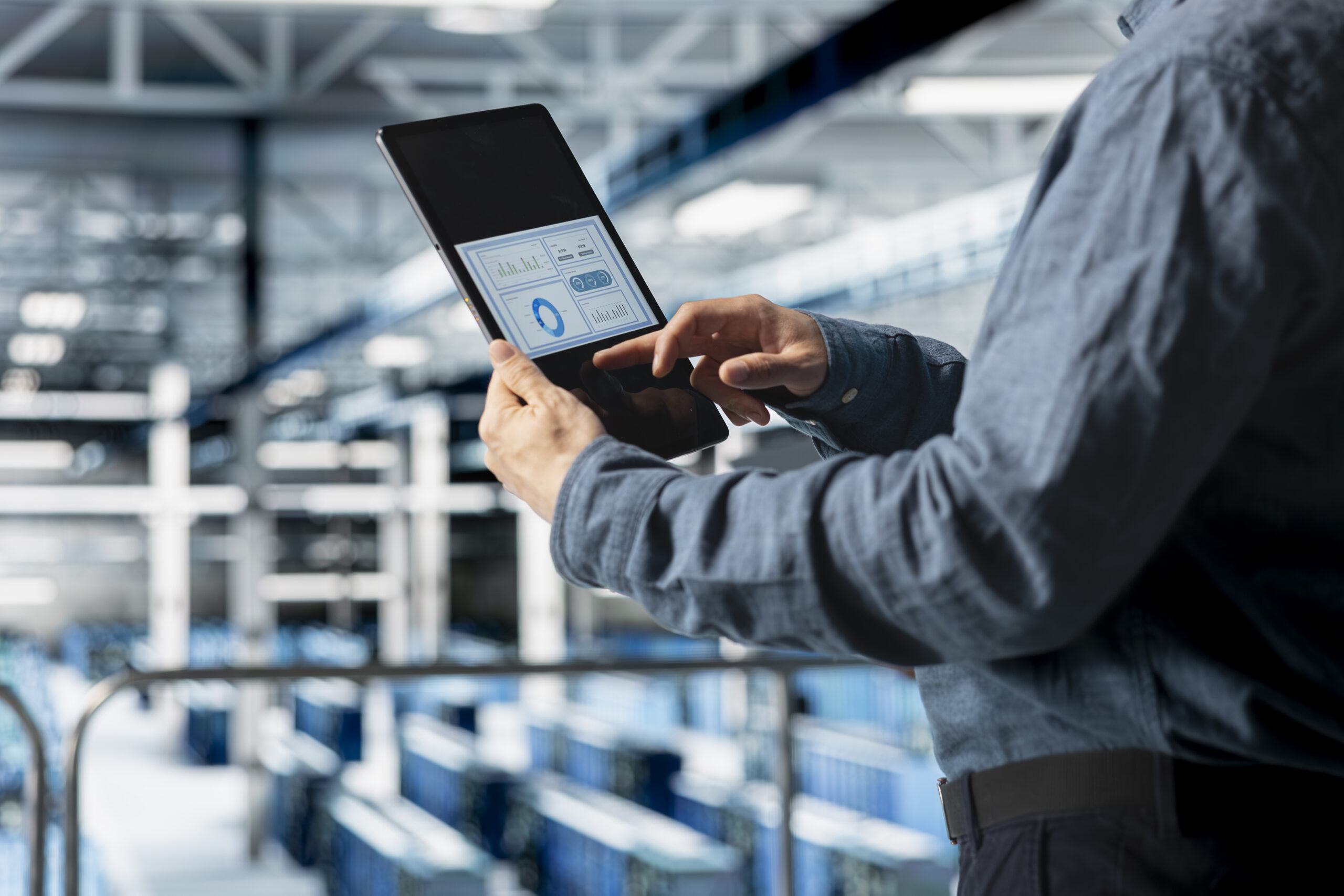 Close up of server room employee analyzing equipment metrics on device screen Close up of server room employee analyzing equipment metrics on device screen